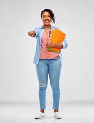 Wall Mural - education, school and people concept - happy african american young student woman with notebooks over grey background