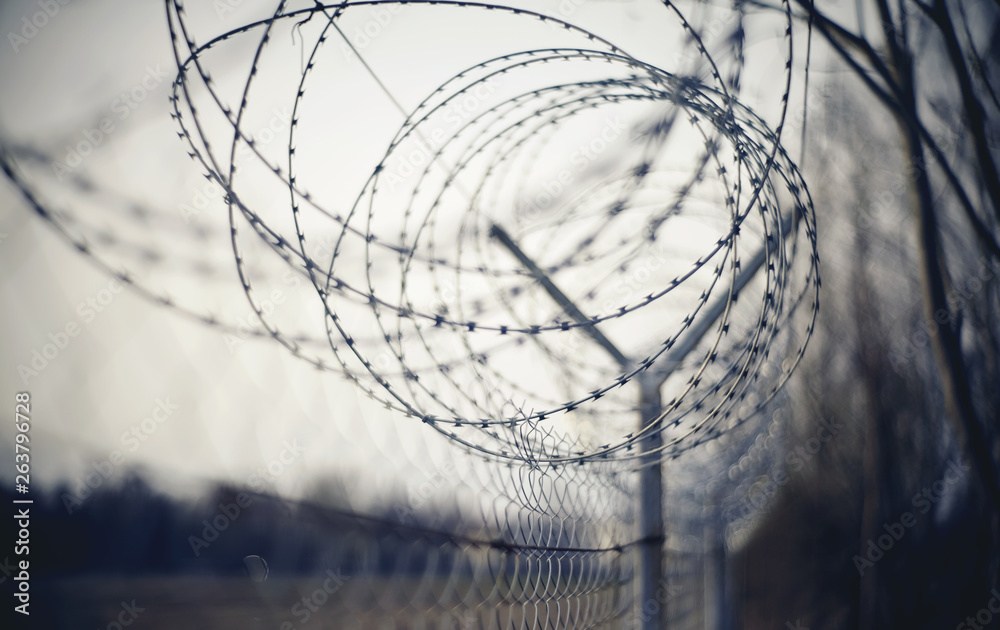 Abstract blurred background with barbed wire. - obrazy, fototapety, plakaty 