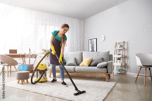 Fotografía Female janitor with vacuum cleaner in room