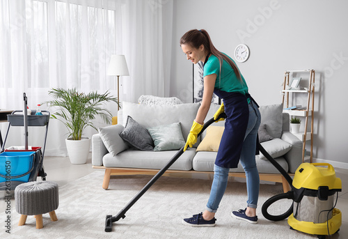 Cuadros en Lienzo Female janitor with vacuum cleaner in room