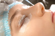 Young woman undergoing procedure of eyelashes lamination in beauty salon, closeup