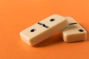 Playing dominoes on a orange table. Domino effect.