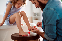Young Father Painting Small Daughter's Nails In A Bathroom At Home.