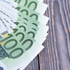 Euro banknotes in fan at wooden background.