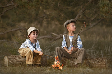 Wall Mural - Two friends are resting by the fire in the woods