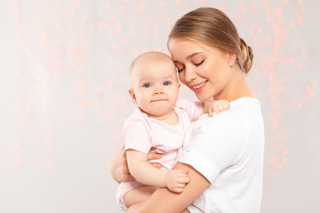 portrait of happy mother with her baby against blurred lights. space for text