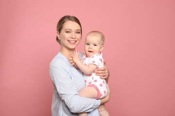 portrait of happy mother with her baby on color background