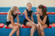 © MIHAJLO CKOVRIC/Stocksy - Gymnastic, happy young girls sitting at the bench and talking