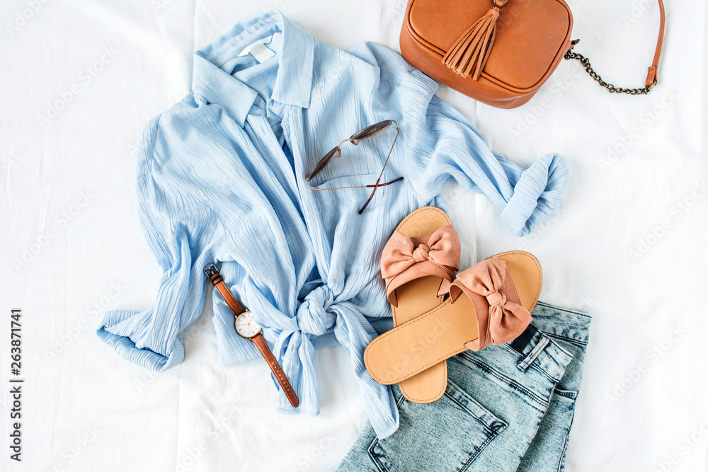 Feminine summer fashion composition with blouse, slippers, purse, sunglasses, watch, jean shorts on white background. Flat lay, top view minimalist clothes collage. Female fashion blog, social media. - obrazy, fototapety, plakaty 