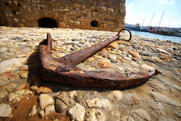 Heraklion, Greece, 25 September 2018, Old anchor at the port of Heraklion with the fortress as a backdrop