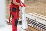 Fototapeta Na sufit - Woman carrying gutter on construction site