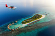 Wasserflugzeug fliegt über eine tropische Malediven Insel bei Sonnenuntergang