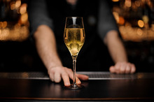 Close shot of glass with sparkling wine in the bartender's hands