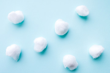 Dentistry concept. Flat lay of teeth like cotton balls on blue surface. Abstract background.