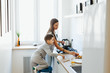 © Elena Kratovich - Happy mother with son cooking omelet in kitchen at home