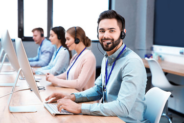 Technical support operator working with colleagues in office