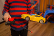 © Ivan - child playing with a wheelchair with a remote at home. radio controlled car toy for children. Boy with joystick plays with a toy car at home.