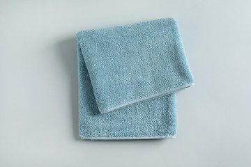 Fresh fluffy folded towel on grey background, top view. Mockup for design