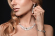 © New Africa - Beautiful young woman with elegant jewelry on dark background, closeup