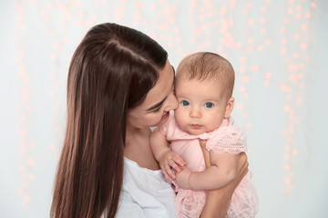 Poster - Portrait of happy mother with her baby against blurred lights