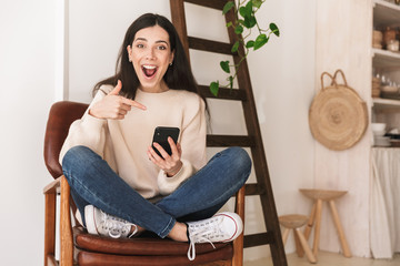 Poster - Photo of adorable cauasian woman 20s using cell phone while sitting on chair