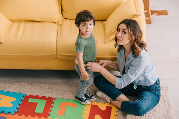 Wall Mural - mother and son with alphabet puzzle mat in living room