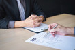 © Ngampol - Employer or recruiter holding reading a resume during about colloquy his profile of candidate, employer in suit is conducting a job interview, manager resource employment and recruitment concept