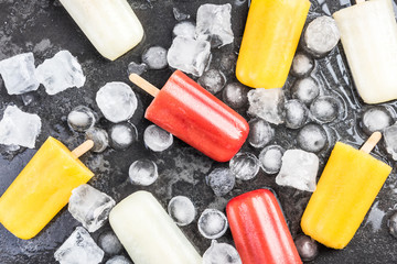 Wall Mural - Colorful healthy popsicles over ice cubes