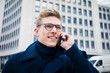 © Westend61 - Portrait of smiling young man talking on cell phone in the city