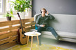 © Westend61 - Relaxed young man with tablet and guitar listening to music with headphones