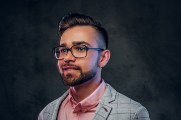 Portrait of young smiling man in checkered blazer, pink shirt and glasses