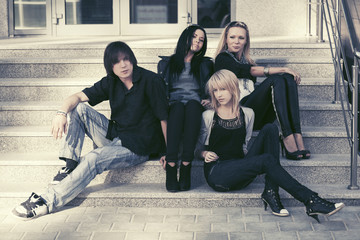 Young fashion people sitting on the steps