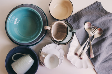 Wall Mural - top view of ceramic tableware and cutlery in soft pastel neutral tones. Modern tableware for home