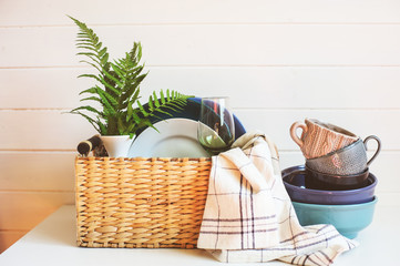 Wall Mural - stack of modern tableware in basket. Cleaning and organizing kitchen in spring