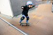 © Cavan Images - A young boy stays focused and balanced while skating a half pipe