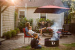 © Cavan Images - a family sitting together in backyard at sunset