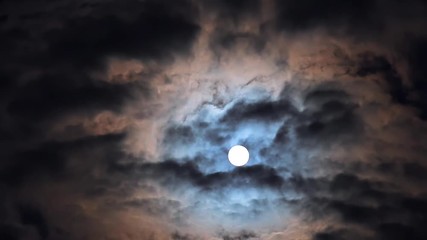 Wall Mural - Full moon in night blue sky with fast moving clouds, dramatic mysterious atmosphere
