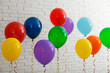 © New Africa - Bright balloons near brick wall. Celebration time