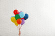 © New Africa - Bunch of bright balloons near brick wall, space for text. Celebration time