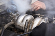 Man mechanic repair a smoking engine of his overheated car