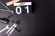 © bychykhin - Labour day. May 1st. Day 1 of may month, calendar on black background with workers tools with empty space for text