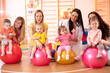 © Oksana Kuzmina - Group of young moms and their babies doing yoga exercises on gymnastic balls at fitness gym