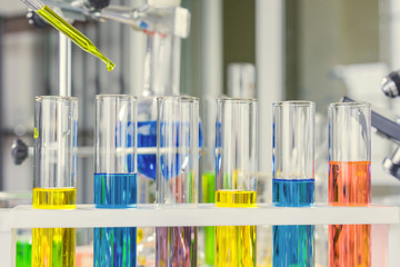 scientist with equipment and science experiments, laboratory glassware containing chemical liquid for research or analyzing a sample into test tube in laboratory