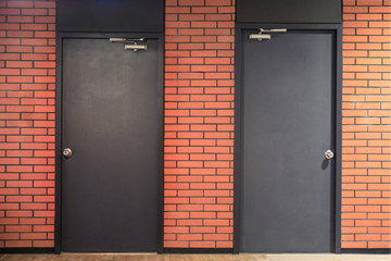 two black doors on red brick wall