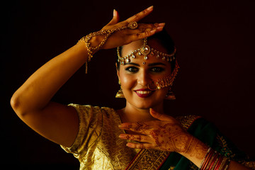 indian beautiful fashion brunette woman in green traditional wedding rich sari with gold jewelry set