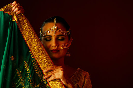 hindu princess lady in green traditional sari with tatoo mehndi and kundan jewelry . Tradition Indian bride costume lehenga choli golden kundan jewelry set model with perfect make-up India