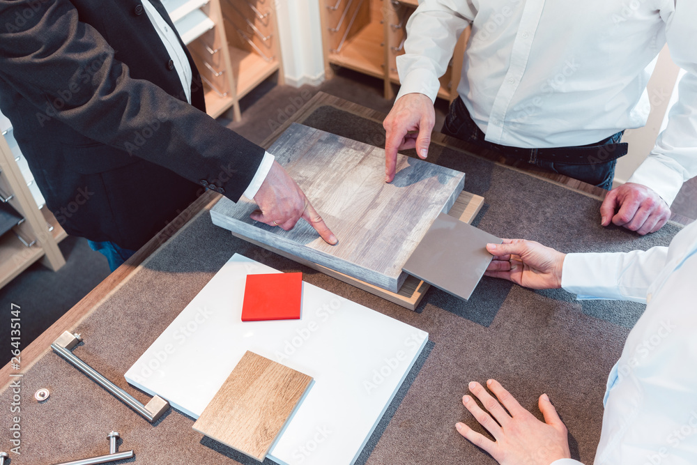 Woman and man with salesman choosing details of their new kitchen
