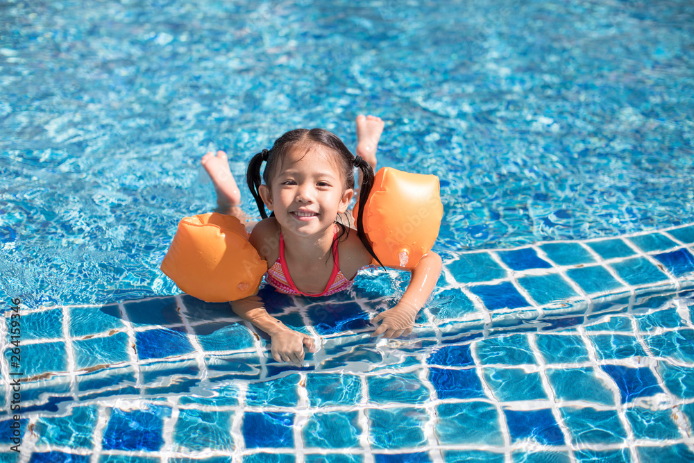 Happy little girl swimming in swimming pool Stock Photo | Adobe Stock