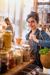 Wall Mural - Beautiful young woman shopping in a bulk food store