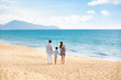 © Blue Jean Images - Happy young family walking on beach